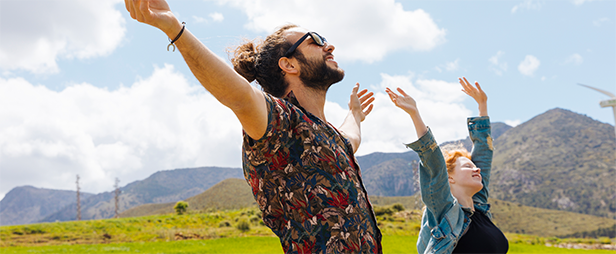 Young couple with hands up in nature